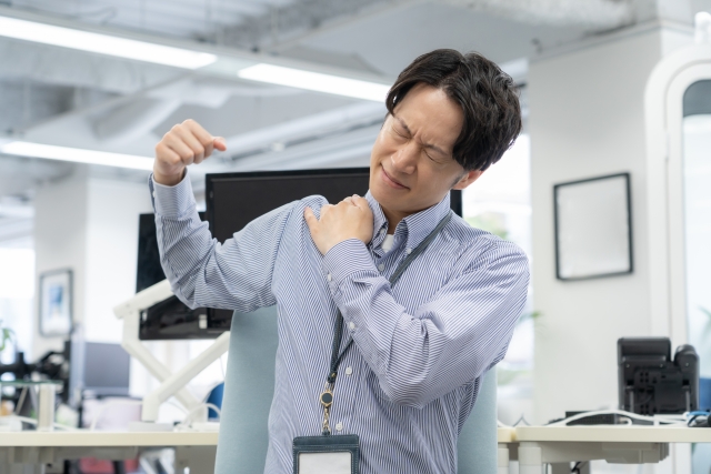 オフィスで肩を押さえる男性