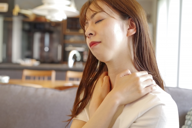 髪をおろして肩を押さえる女性
