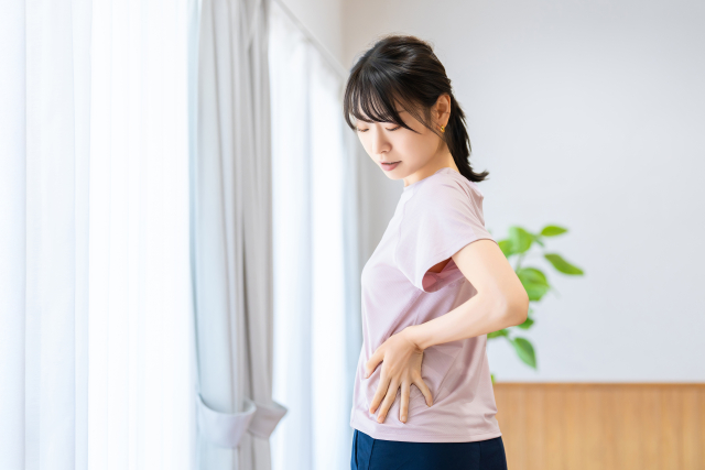 腰回りを押さえる女性のイメージ あさば整骨院 八潮店